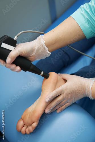 Female patient receiving shockwave therapy treatment in clinic