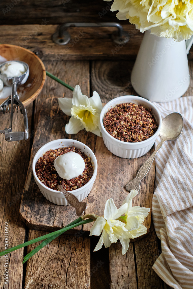 Crumble with apple and chocolate. Narcissus, ice cream, wood background, side view, vensa. Crumble with apple and chocolate. Narcissus, ice cream, wood background, side view, vensa.