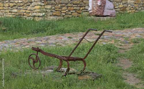 Vintage agricultural equipment for manual tillage. Vintage decoration in a Bessarabian village. A metal tool used in the early 20th century. Odessa Oblast, Ukraine.