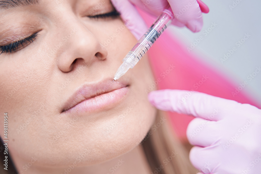 Dermatologist carrying out mesotherapy procedure with disposable syringe