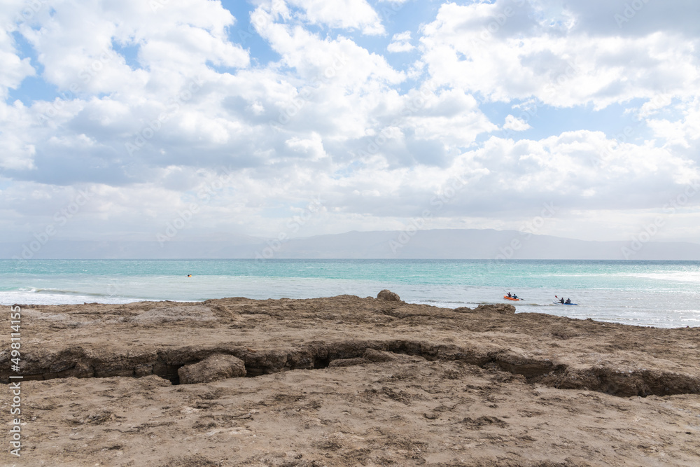 Exotic view of the sinkhole area of the Dead Sea on a stormy winter day. PhotoStorm and rain at the Dead Sea coastline. Salt crystals at sunset. The texture of the Dead sea. Salty seashore. High