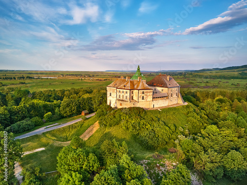 Obraz na płótnie Medieval Olesko Palace aerial view. Picturesque sunny scene, green spring trees. Summer park on hills. w salonie