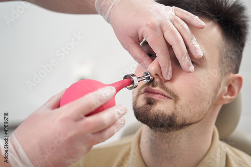 Young man during prosedures for nose in clinic photo