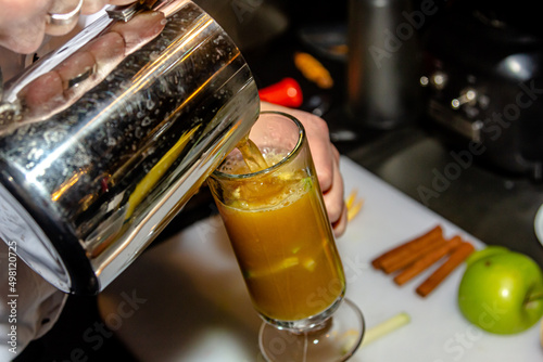 The bartender at the bar prepares orange grog photo