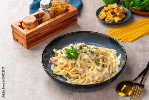 homemade fettuccine pasta with white cream sauce. fettuccine Carbonara made with eggs, hard cheese, cured pork, and black pepper. Italian food.