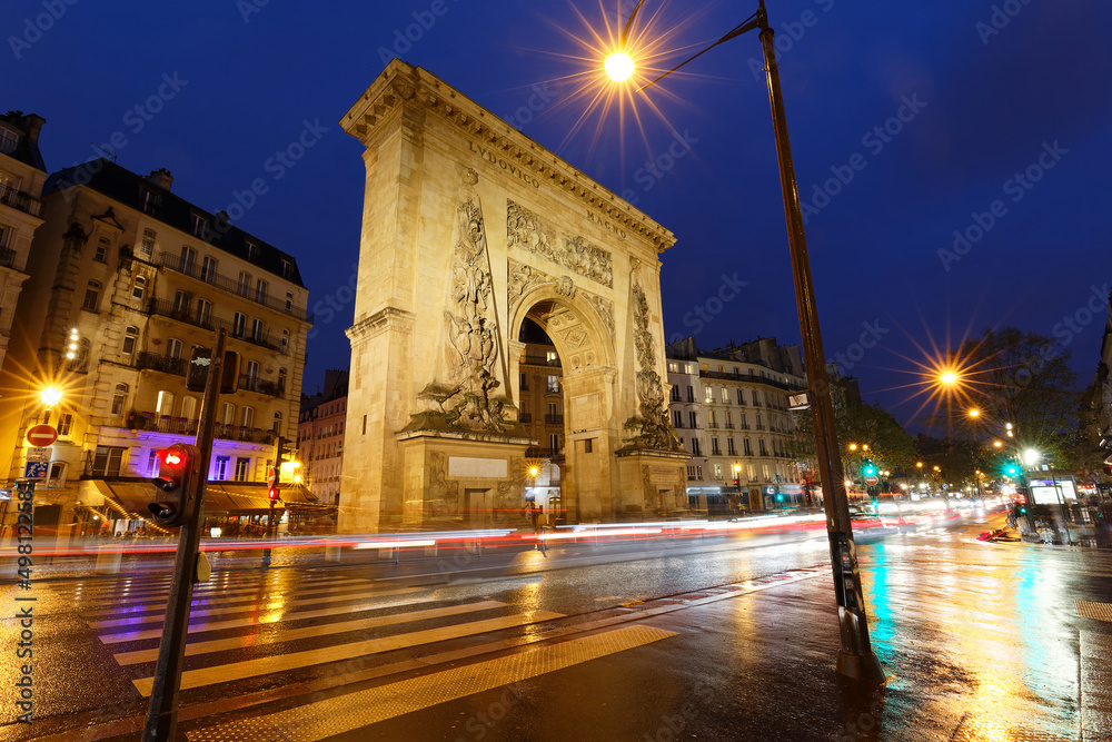 Porte Saint-Denis at rainy night . It is a Parisian monument located in the 10th arrondissement of Paris, France. - obrazy, fototapety, plakaty 