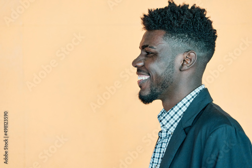 Fototapeta Naklejka Na Ścianę i Meble -  Happy Emotions. Portrait Of Laughing African American man Posing Over yellow Background, Cheerful Young Curly Black man Having Fun, Having Good Mood, Side View Shot, Copy Space