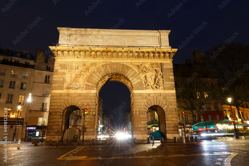 Paris, the porte Saint-Martin, beautiful ancient gate near the Grands Boulevards at rainy night.
