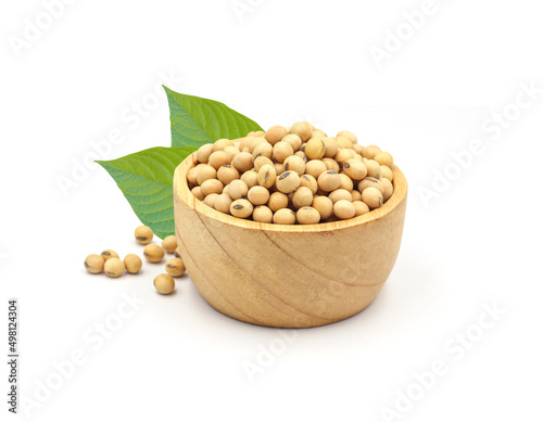 soybean seeds in wooden bowl with green leaves isolated on white background