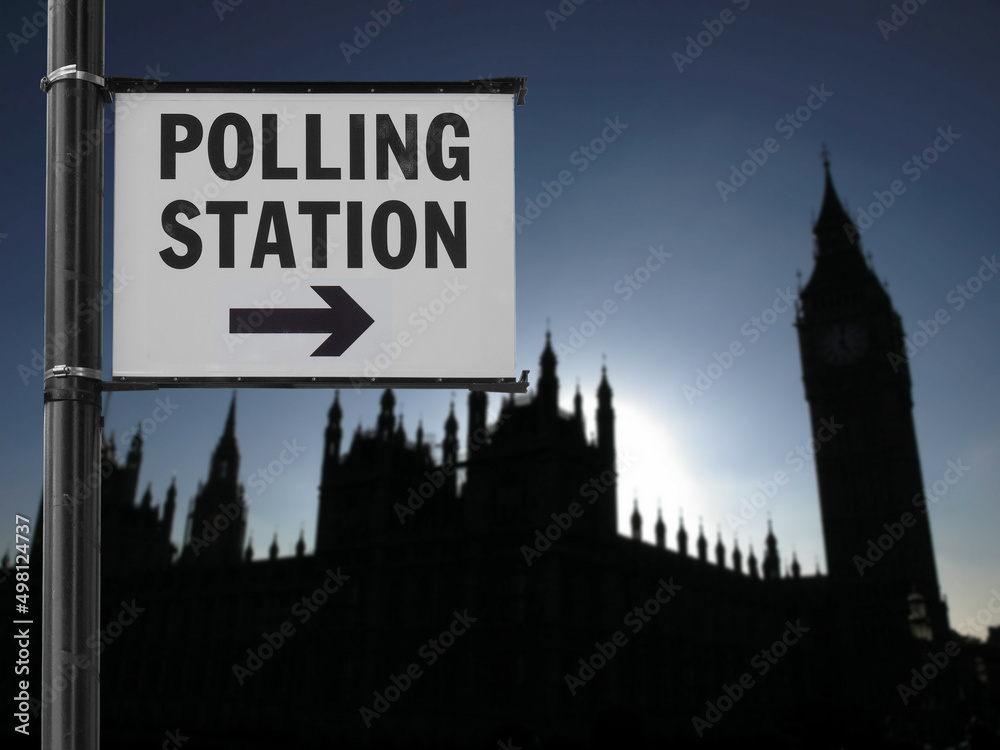 polling station sign over blurred parliament background