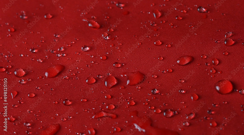 Waterproof textile cloth concept. Rain, water drops are splashing on coat but waterproof is saving from be wet.
