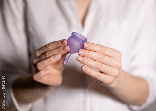 Young woman hand holding menstrual cup. Selective focus and shallow DOF