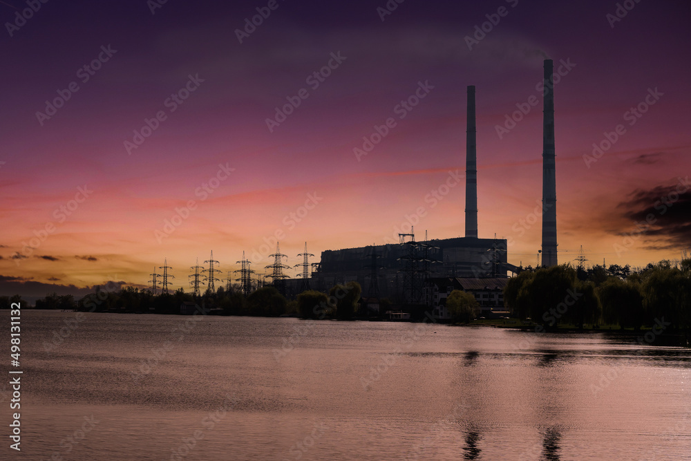 Smoke from the chimney at the plant against the backdrop of the sunset.