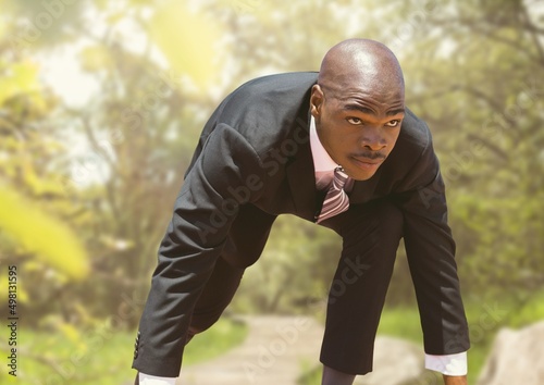 Composite image of african american businessman in starting position against forest in background photo