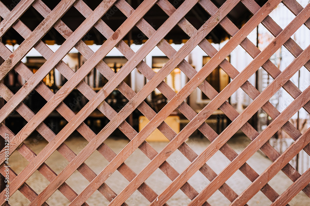 Background, texture of a fence made of a wooden lattice, made crosswise.