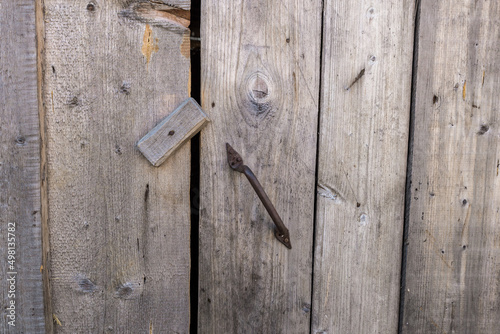 closed door with iron handle. door closed with a wooden catch
