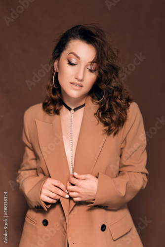 beautiful young woman in a beige jacket with a choker around her neck