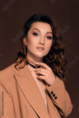 beautiful young woman in a beige jacket with a choker around her neck