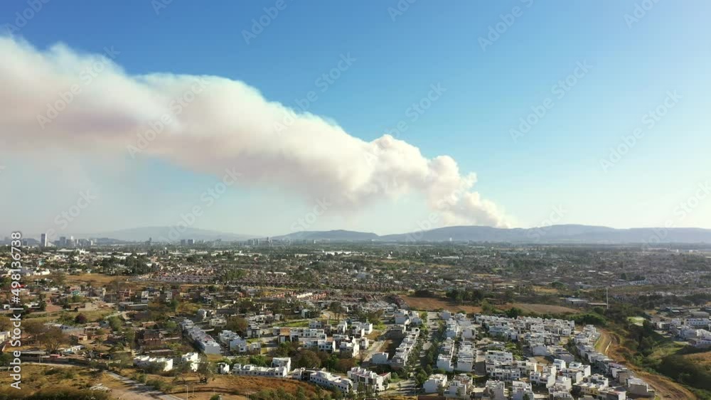 Incendio en montaña campo cerro cerca de ciudad casas viviendas gran cantidad de humo saliendo por el fuego caliente 