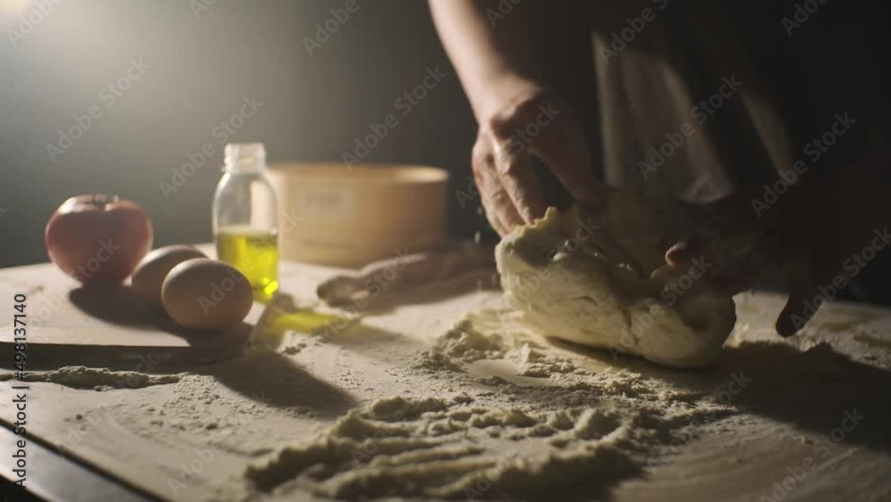 Close up of bakery chef kneading dough with hands, for making bread according to traditional recipe, isolated on black background Close up of bakery chef kneading dough with hands, for making bread according to traditional recipe, isolated on black background