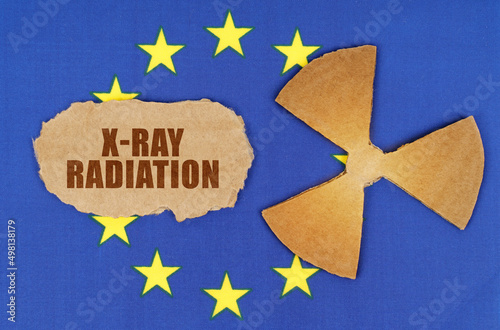 On the flag of the EU, the symbol of radioactivity and torn cardboard with the inscription - X-Ray Radiation