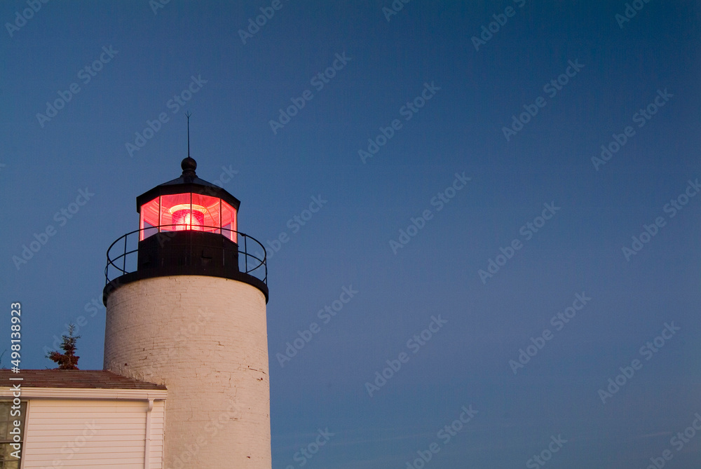 Sunset lights up the white bricks of the Bass Harbor Lighthouse on the Maine Coast