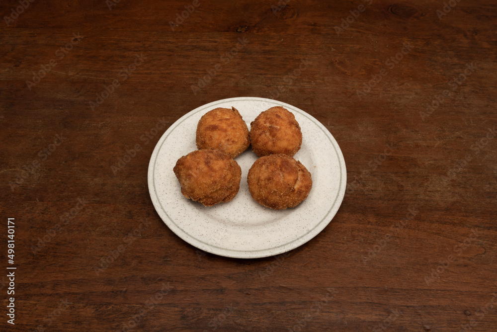 Delicious round croquettes of fresh cheese and ham tacos on a circular plate served in a Spanish tapas restaurant Delicious round croquettes of fresh cheese and ham tacos on a circular plate served in a Spanish tapas restaurant