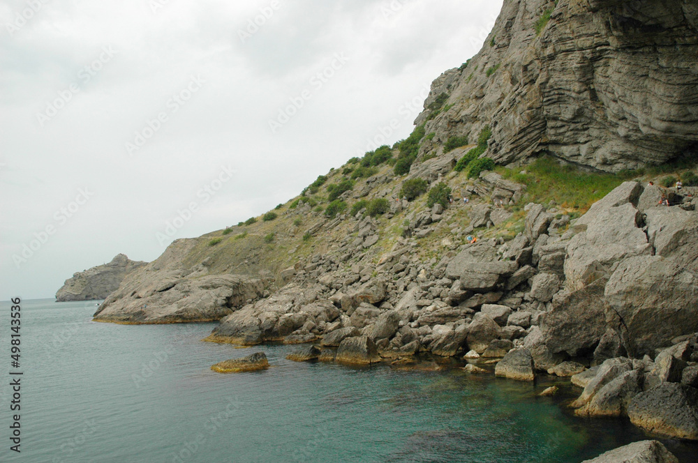 Fototapeta premium Scenic view of huge cliffs and sea. Sea bay surrounded by rocky mountains. The Black Sea coast is surrounded by rocks and mountains. Rocky shore, ripples on the sea water. Crimea. The Golitsyn Trail