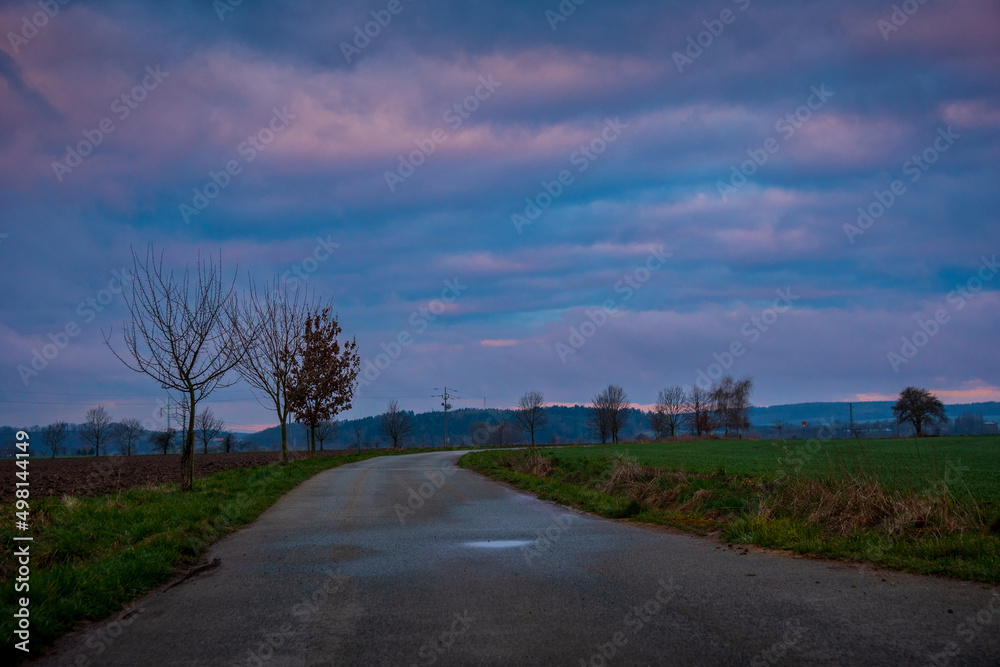 Fototapeta premium Sunrise over the road and fields