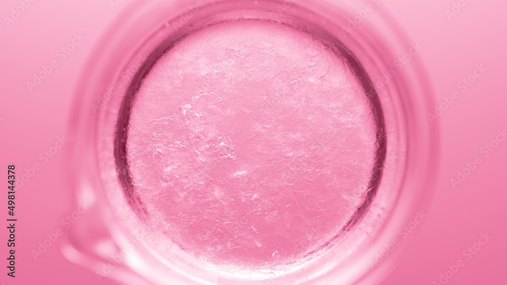 Top view macro shot of glycerin being poured into beaker with water creating solution on pink background | Abstract body care cosmetics formulation concept Top view macro shot of glycerin being poured into beaker with water creating solution on pink background | Abstract body care cosmetics formulation concept