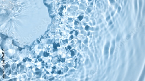 Water being poured creates ripples and waves on blue background | beauty product background, sunscreen commercial