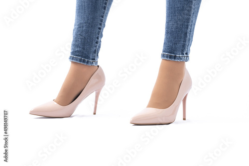 Slender female legs in patent leather shoes with high heels. Dark blue jeans. Fashion and Style. Side view