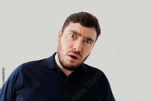 Bearded young man is surprised and dumbfounded, he looks at the camera with a stupid expression on face. man with intense expression
