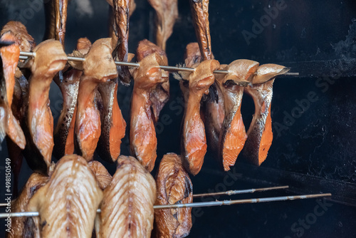 Freshly smoked fish hanging in smoke in a smokehouse. The tradition of preparing fish from the Baltic Sea.