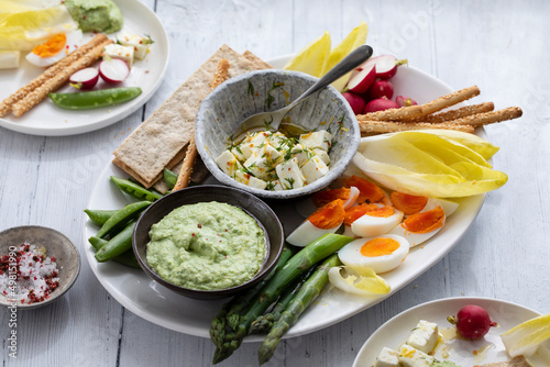 Easter sharing platter with eggs, asparagus, crunchy vegetables and feta
