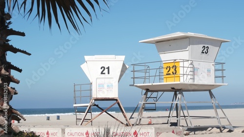 Lifeguard stand and palm tree, life guard tower for surfing on California beach. Summer pacific ocean in USA aesthetic. Iconic rescue baywatch station, coast lifesavers wachtower hut or house by sea.