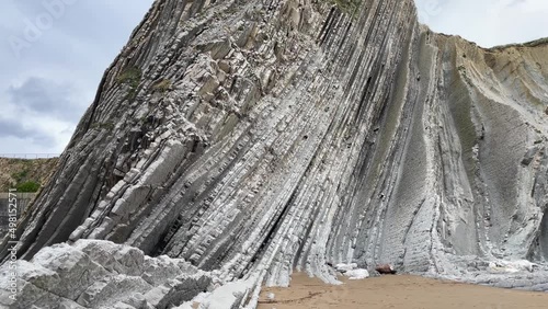 Flysch limestone rock mountain at Itzurun beach on cloudy day in Zumaia, Basque Country. Game of Thrones tv series location landmark photo