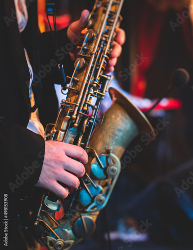 Concert view of a saxophonist, saxophone sax player with vocalist and musical during jazz orchestra performing music on stage