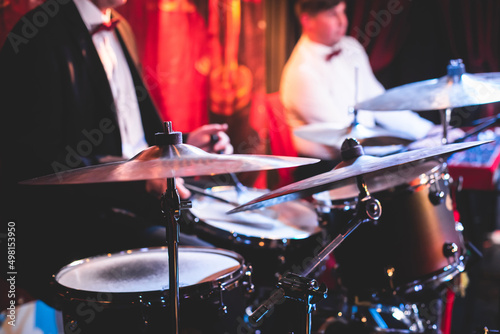 Photography Drummer percussionist performing on a stage with drum set kit during jazz rock s