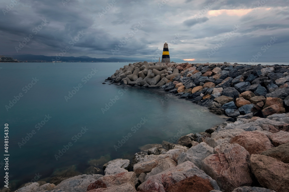 Dramatic cloudy morning scenery of lighthouse at Banalmadena, Malaga, Spain 