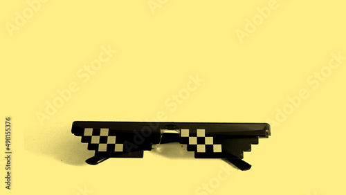 Pixel 8bit style. Funny swag pixilated thug life sunglasses on yellow background. Gangster meme glasses. 