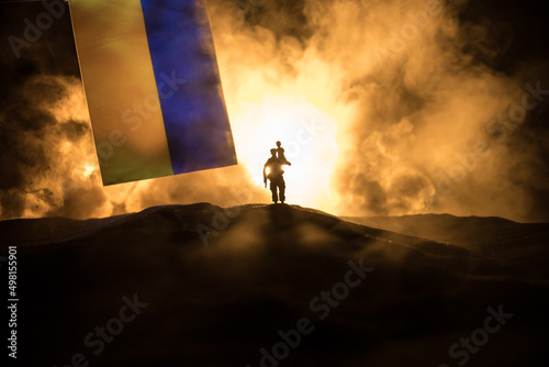 Fotografia Silhouette soldier carrying little boy on his shoulder from fire