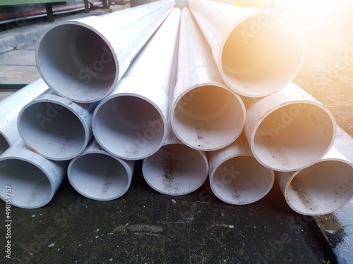 Pile of paralon pipes for industrial work with shiny lights. Indistrial pvc piping.