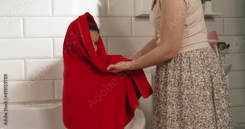 Wiping the baby with a towel after the bath. Mom's care for children.