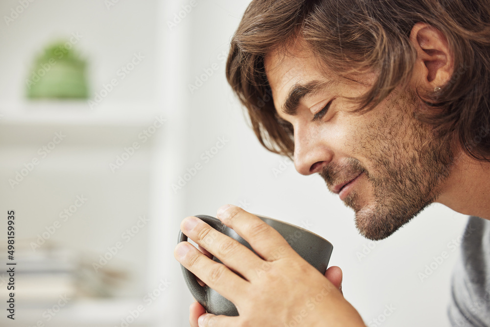 A cup a day keeps the doctor away. Shot of young man drinking a cup of coffee happily..