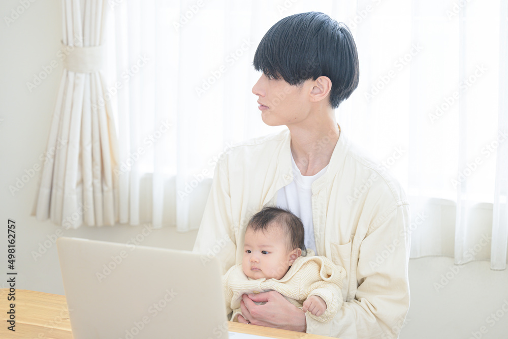 育児をしながら在宅をする若いパパさん 横向き 育児をしながら在宅をする若いパパさん 横向き