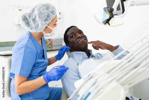 Male patient complaining to doctor dentist about toothache