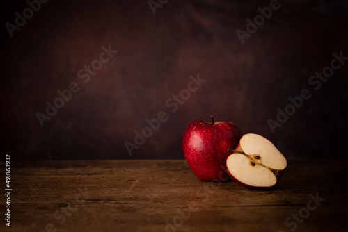 One Whole Apple and One Half Apple on a Wooden Old Surface. Kitchen Table Concept