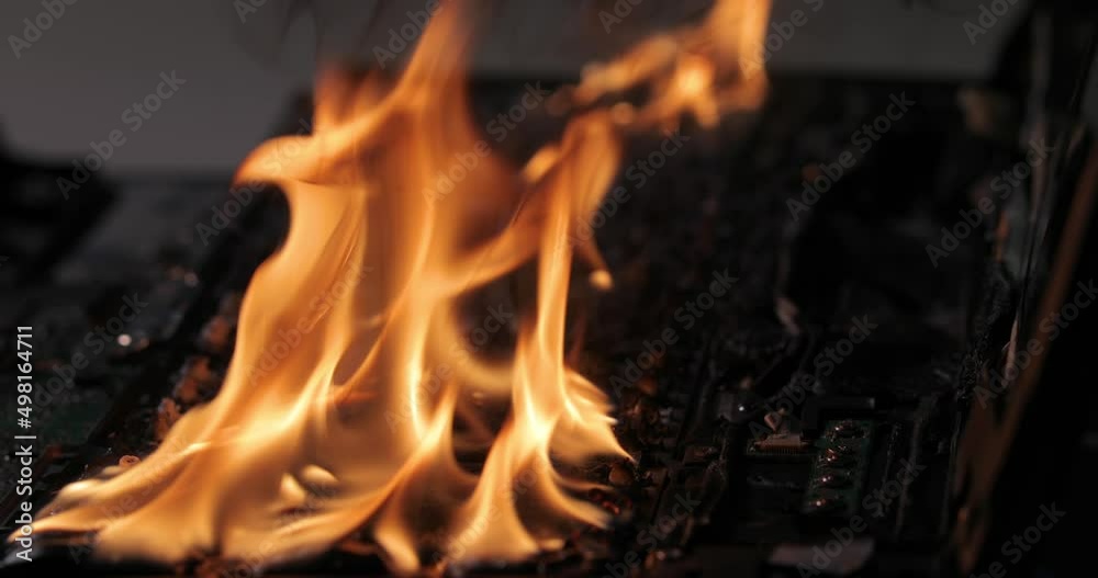 Burning laptop computer electronics closeup Burning laptop computer electronics closeup