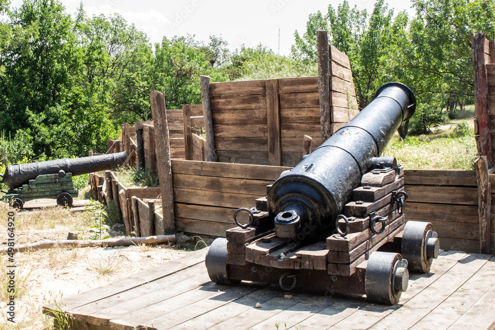 Antique cannon with cannonballs. Defense of the city. Historic site.